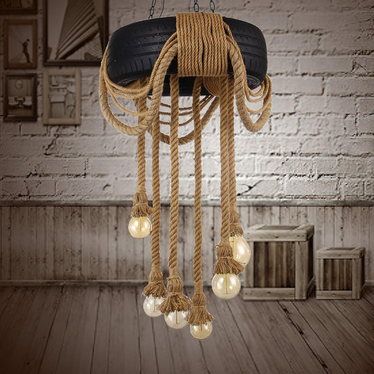 Chandelier lit in a white brick room beside a wood crate and a bench