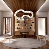 The lit tube above a round rug in a study with shelves, a desk and two chairs