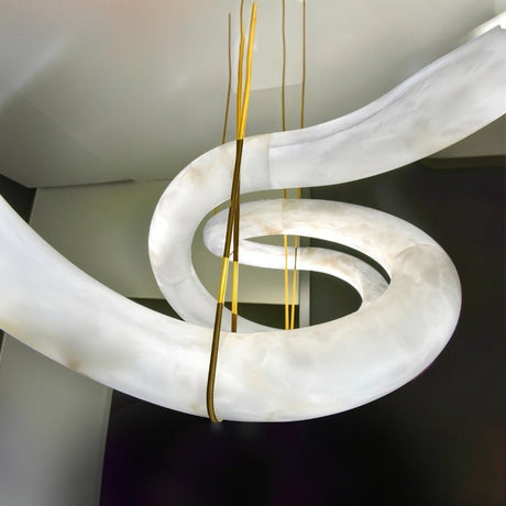 The curve of the alabaster tube where a brass cable meets the stone