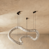 The same winding alabaster tube unlit, the stone pale against plaster
