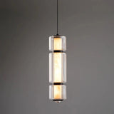 The lit marble cylinder seen against a dark wall with its glass sleeve
