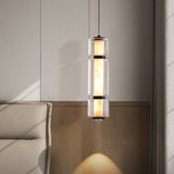 The marble and glass pendant lit above a sofa corner against a pale wall