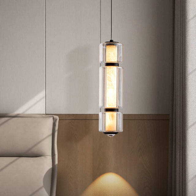 The marble and glass pendant lit above a sofa corner against a pale wall
