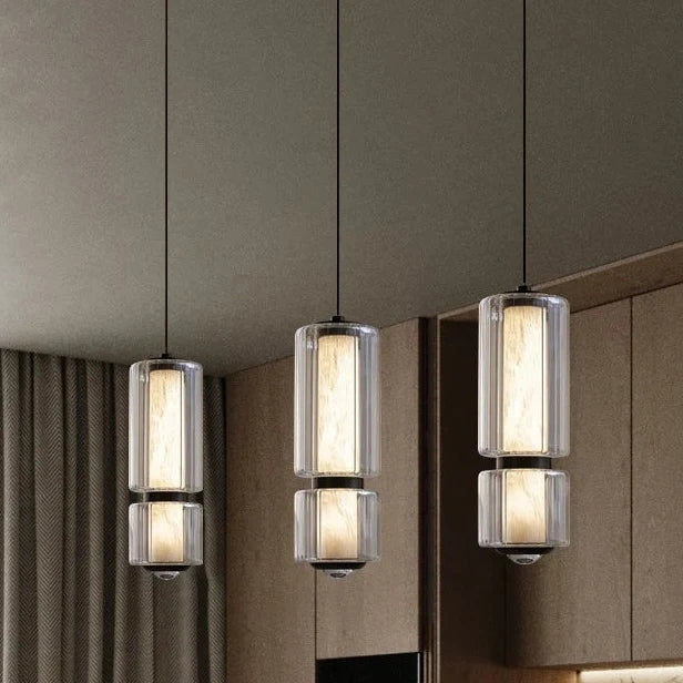 Three marble and glass pendants lit in a row above a counter
