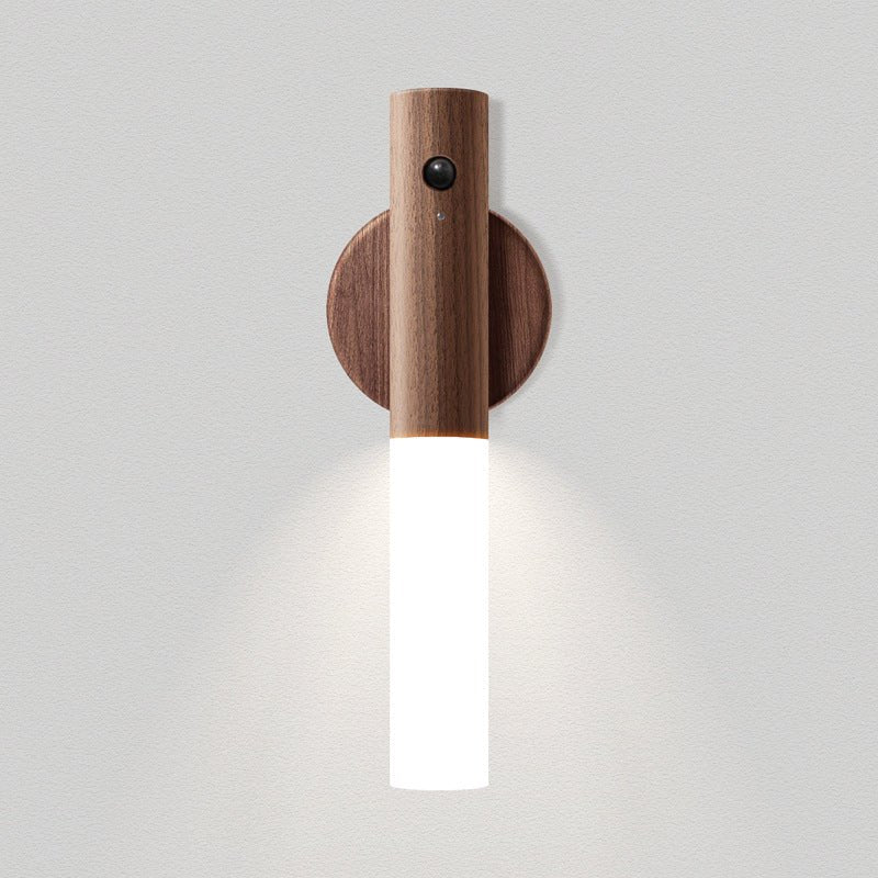 The light wood collar on its plate, the frosted tube lit against pale gray