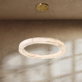 The lit ring on a plaster ceiling with sunlight falling across the wall