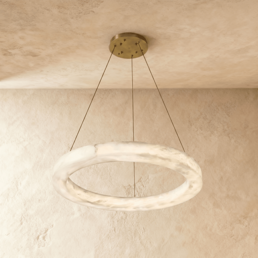 A smaller alabaster ring on three cables below a round brass plate