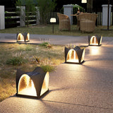 Lit petal caps along a garden path beside planters and a timber fence