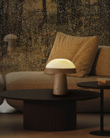Stone table lamp lit on a round coffee table in a dark lounge