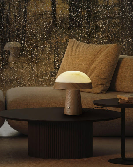 Stone table lamp lit on a round coffee table in a dark lounge