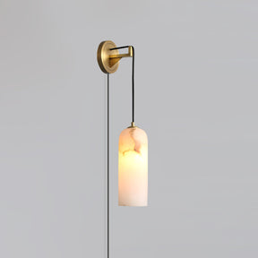 The brass version lit, hanging on a plain gray wall