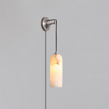 The nickel version lit, hanging on a plain gray wall