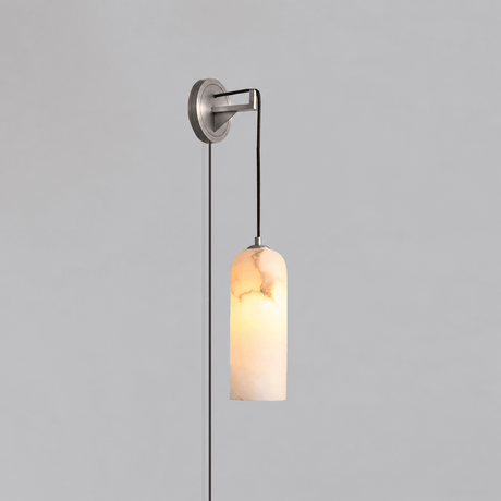 The nickel version lit, hanging on a plain gray wall