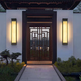 A pair lit either side of a timber gateway at the end of a paved path