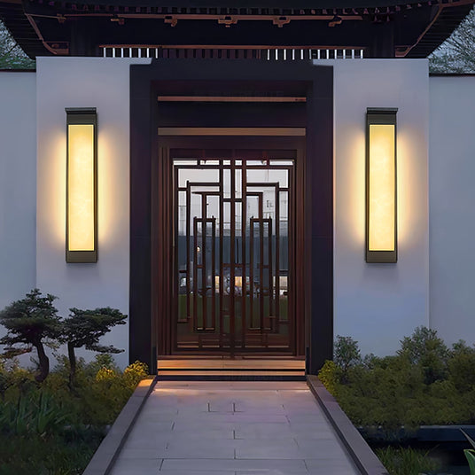 A pair lit either side of a timber gateway at the end of a paved path