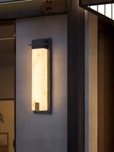 The light on a render wall beside a timber screen and a doorway