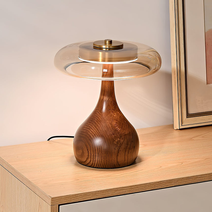 Table lamp with an amber glass shade lit close from the front