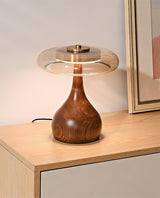 The tall glass shade table lamp lit on a pale wood sideboard