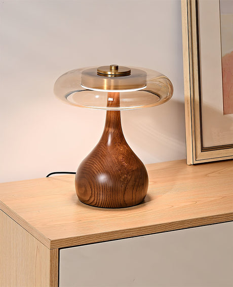The tall glass shade table lamp lit on a pale wood sideboard