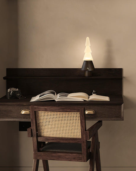 Table lamp with night light lit on a writing desk with an open book