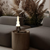 Table lamp with night light lit on a wooden drum table by a sofa