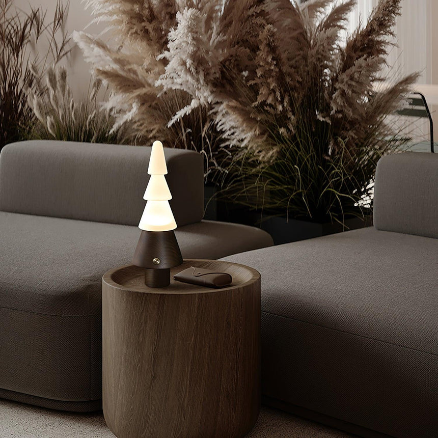 Table lamp with night light lit on a wooden drum table by a sofa