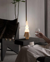 Table lamp with night light lit on a nightstand beside a raised glass