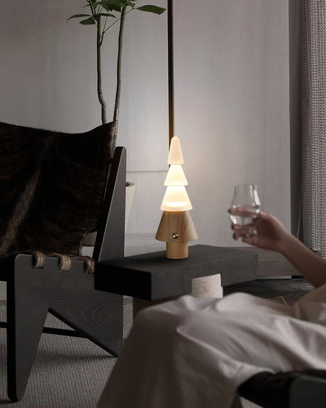 Table lamp with night light lit on a nightstand beside a raised glass