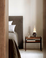 Table lamp with night light lit on a nightstand in a gray bedroom