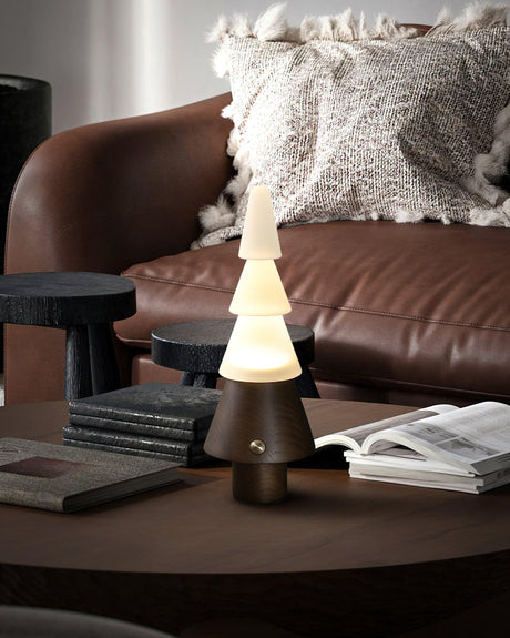 Table lamp with night light lit on a round table beside a leather sofa