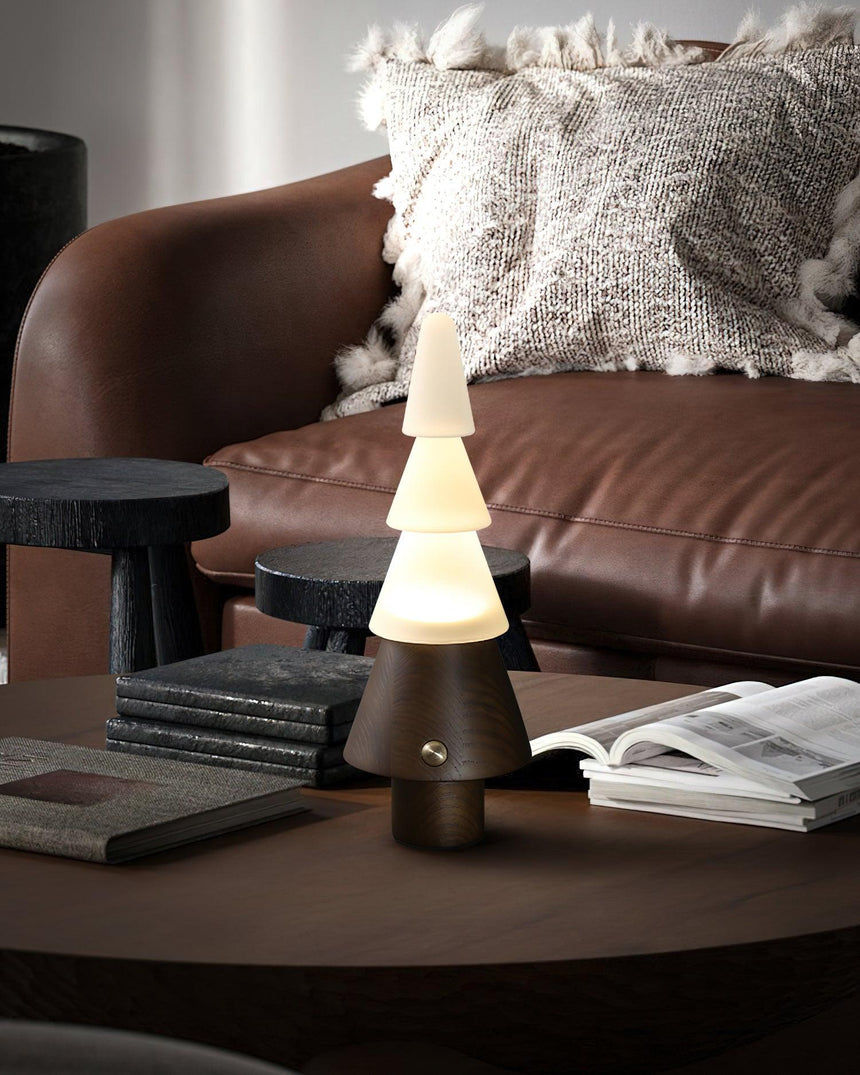Table lamp with night light lit on a round table beside a leather sofa