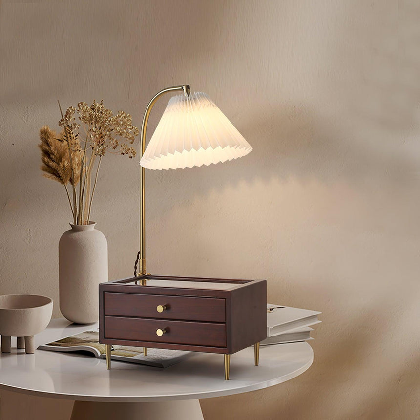 Table lamp with storage lit on a round table beside dried flowers