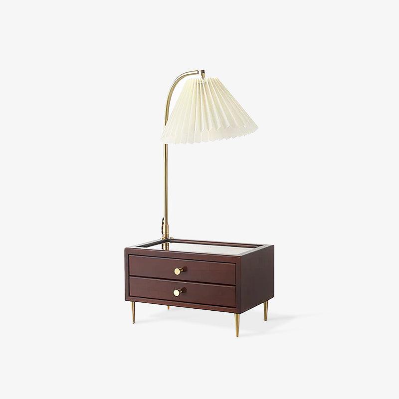 Table lamp with storage seen at an angle, the brass arch curving forward