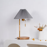 Pleated shade lamp unlit on a plaster console beside a white vase
