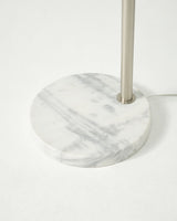 The round white marble base seen close with the nickel pole rising from it