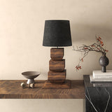 Black shaded tall table lamp on a wooden sideboard beside a bowl