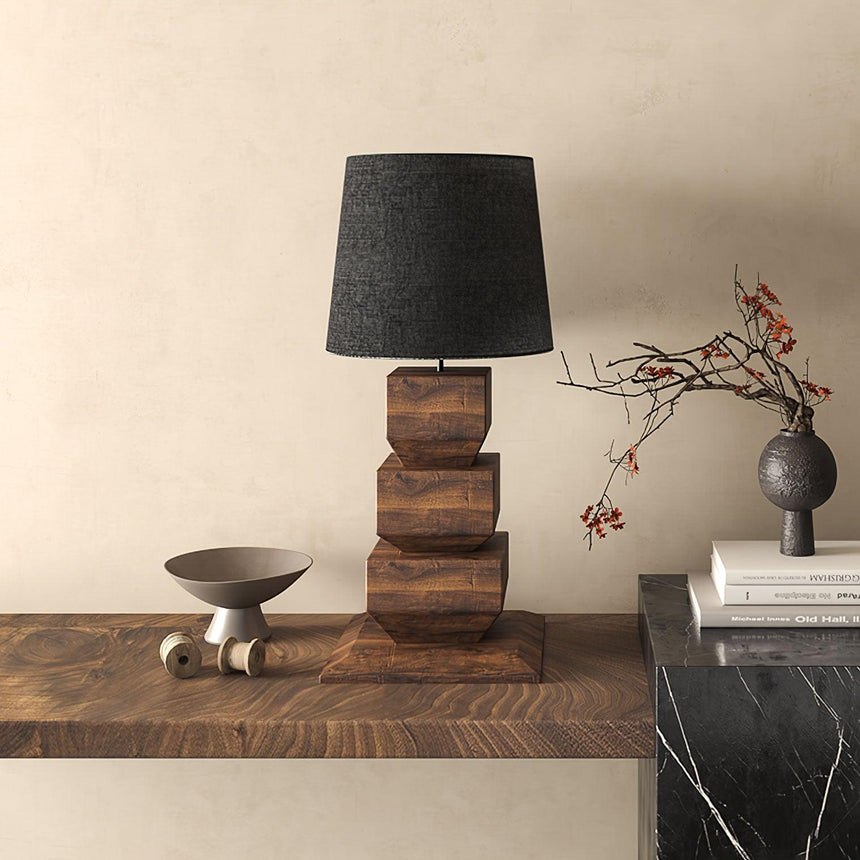 Black shaded tall table lamp on a wooden sideboard beside a bowl