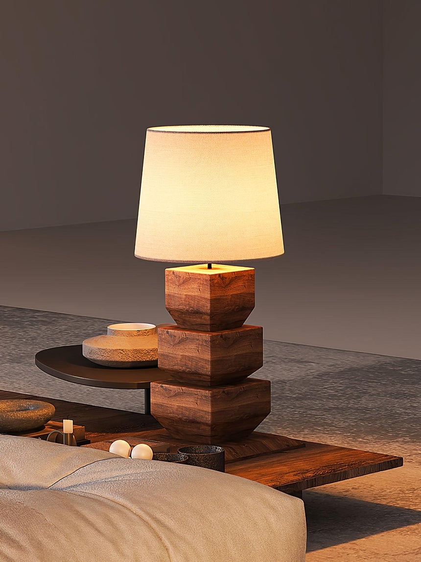 Tall table lamp lit on a low table in a dim room in the evening