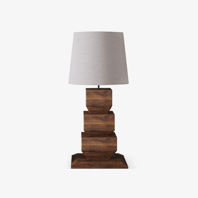 Tall table lamp with a white drum shade on stacked wood blocks, plain background