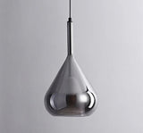 A smoked glass teardrop shade hanging alone on a slim black cord