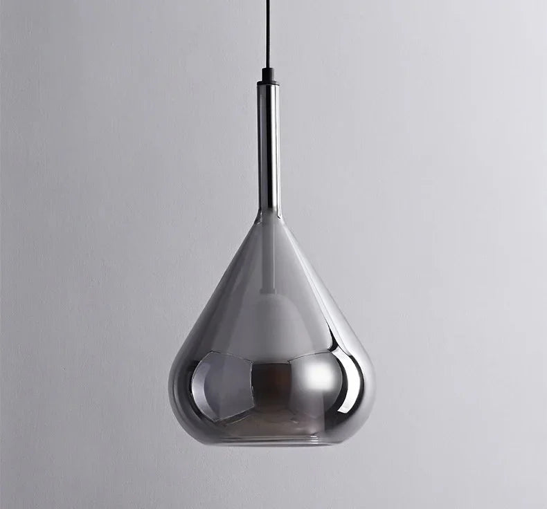 A smoked glass teardrop shade hanging alone on a slim black cord