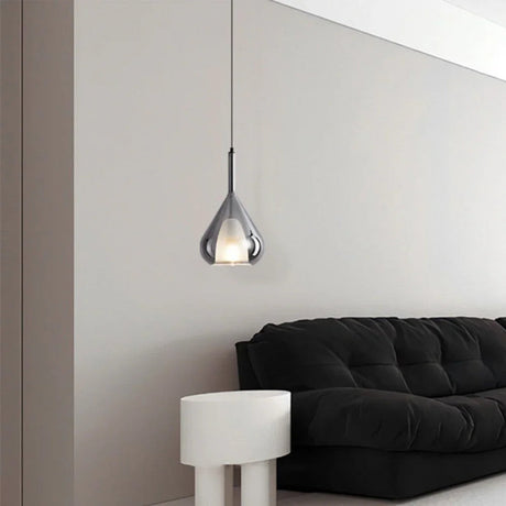 The teardrop lit on a long cord beside a black sofa and a pale side table
