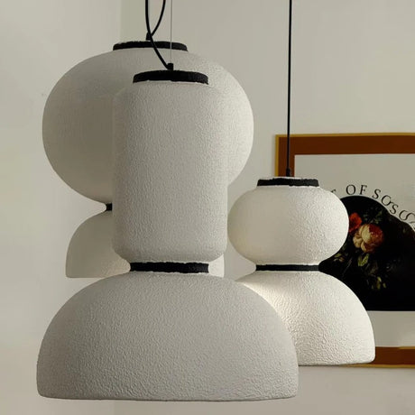 Two textured white pendants beside a framed print