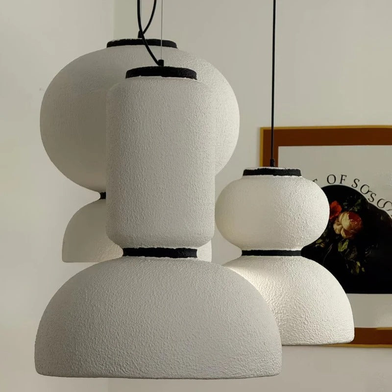Two textured white pendants beside a framed print