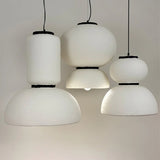 Three textured white pendants hung at staggered heights