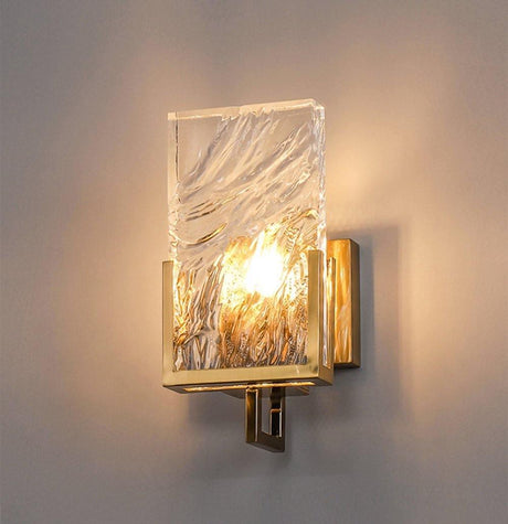 The glass panel lit warm on a beige wall, its rippled surface glowing