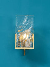 The brass frame and glass panel on a teal wall