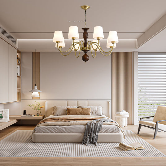 Chandelier lit in a bedroom above a made bed and a bench