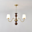 Three light chandelier with white fabric cones on a walnut column