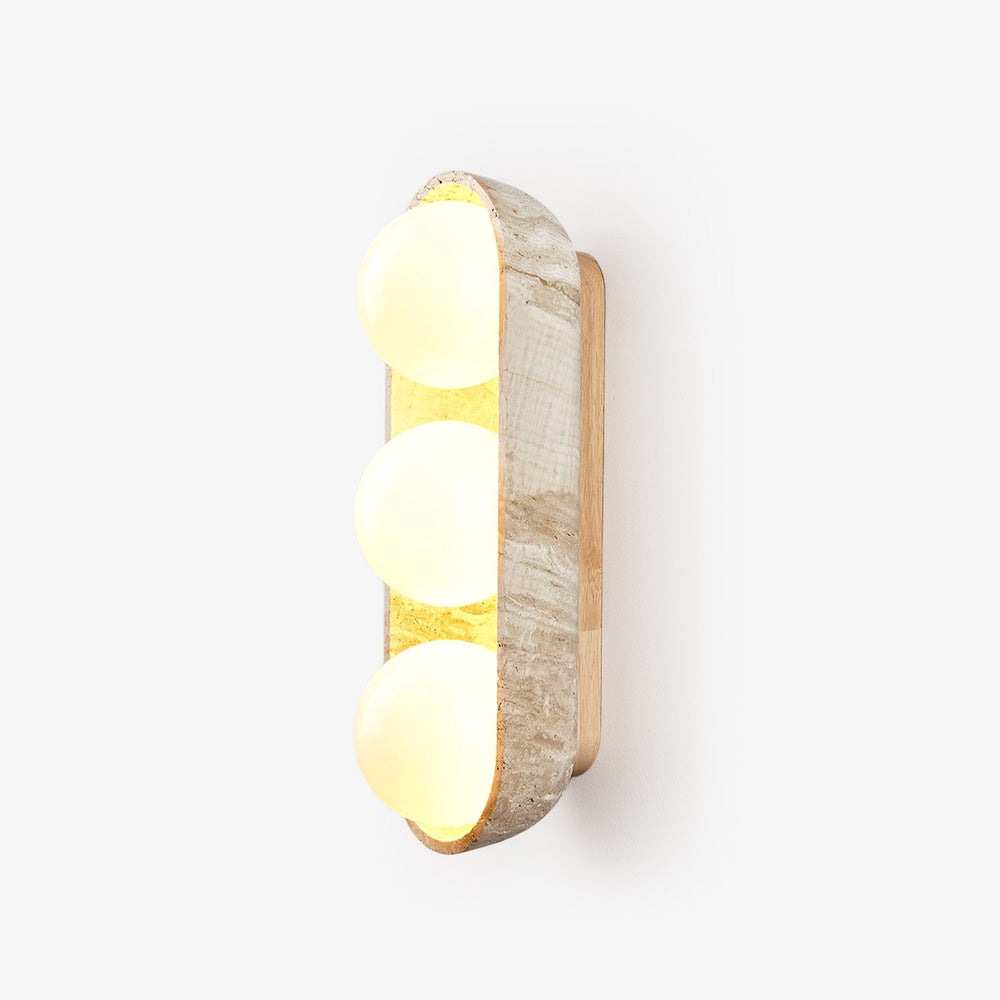 Three light wall sconce, three glass orbs held in a carved travertine shell